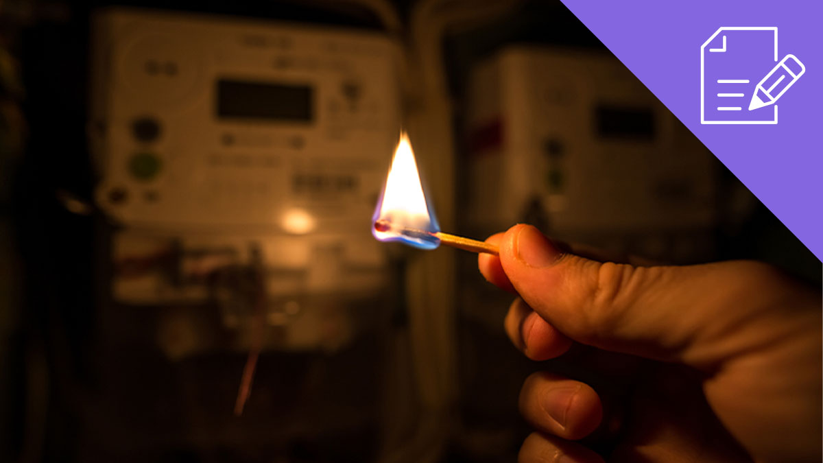 Pessoa a segurar fósforo aceso no escuro junto a quadro elétrico